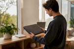 Hände legen eine Laptophülle neben den Rand eines MacBooks